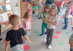dzieci maszerują po kolorowych kropkach
