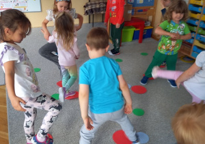 dzieci maszerują po kolorowych kropkach