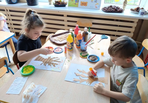 dzieci malują jesienne drzewa