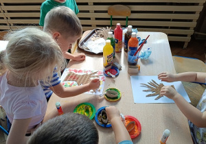 dzieci malują jesienne drzewa