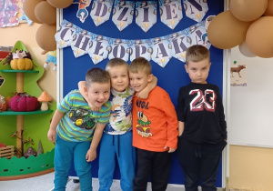 chłopcy pozują do zdjęcia na ściance z balonami