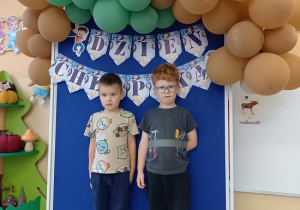 chłopcy pozują do zdjęcia na ściance z balonami