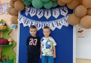 chłopcy pozują do zdjęcia na ściance z balonami