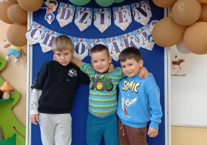chłopcy pozują do zdjęcia na ściance z balonami