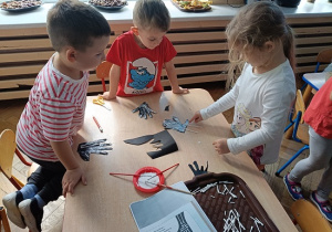 dzieci wyklejają szkielet dłoni papierowej patyczkami kosmetycznymi