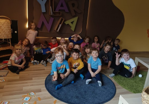 dzieci pozują do zdjęcia przy napisie Motylarnia