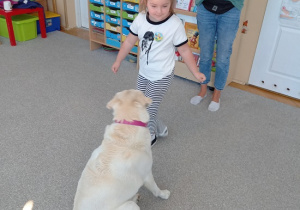 dziewczynka wydaje komendę psu