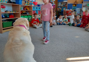 dziewczynka wydaje komendę psu