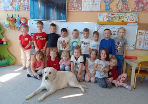 dzieci pozują do zdjęcia z psem