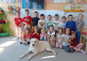 dzieci pozują do zdjęcia z psem