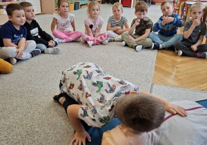 Pan strażak objaśnia dzieciom udzielanie pierwszej pomocy na fantomie