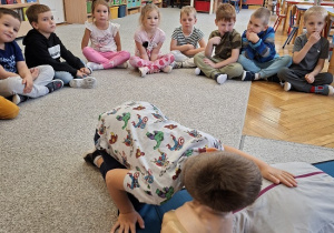 Pan strażak objaśnia dzieciom udzielanie pierwszej pomocy na fantomie