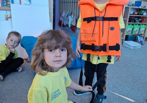 chłopcy zakładają kamizelkę ratunkową