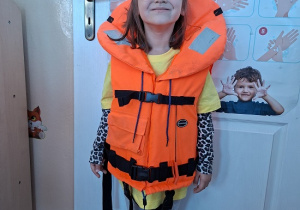 dziewczynka zakłada kamizelkę ratunkową