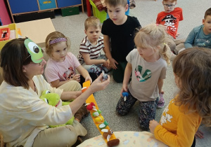 Pani Beatka w masce żabki opowiada dzieciom bajkę