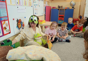 Pani Beatka w masce żabki opowiada dzieciom bajkę