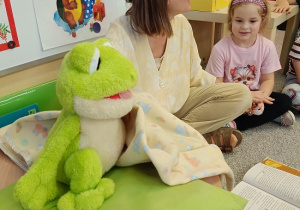 Pani Beatka w masce żabki opowiada dzieciom bajkę