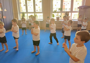 dzieci w strojach gimnastycznych ćwiczą na materacach