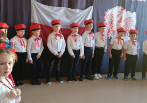 chłopcy w galowych strojach i czerwonych czapkach