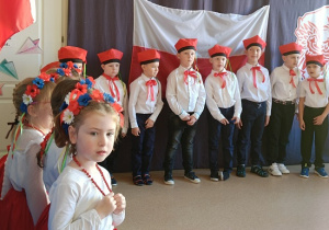 chłopcy w galowych strojach i czerwonych czapkach