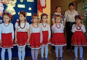 dziewczynki w czerwonych spódnicach i czerwonych koralach