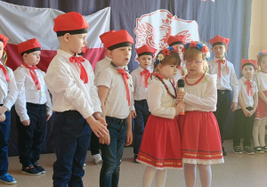 dzieci w biało- czerwonych strojach prezentują wiersze