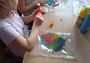 dzieci wykonują pracę plastyczną z wykorzystaniem farb