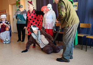 seniorzy przebrani za postacie z bajki pt: "Czerwony Kapturek"