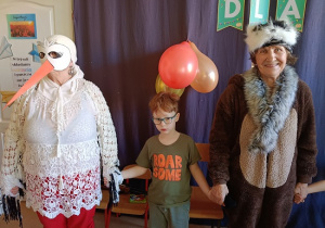 seniorzy w przebrania wspólnie z dziećmi tańczą w kole