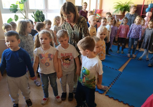 dzieci pozują do zdjęcia w towarzystwie seniorów