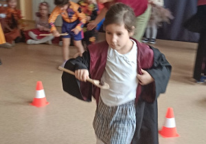 dziewczynka biegnie z kasztanem na łyżce