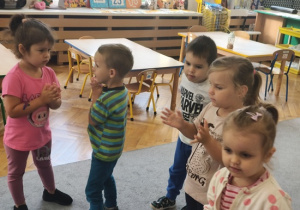 dzieci stoją w grupie i klaszczą w ręce