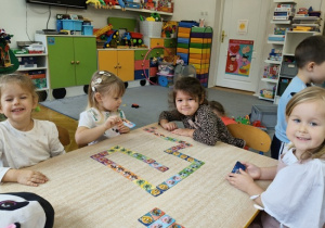 dzieci układają domino na stoliku