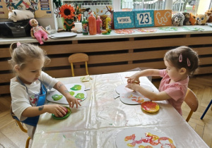 dziewczynki stemplują połówkami jabłka