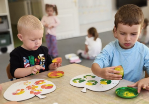 chłopcy stemplują połówkami jabłka