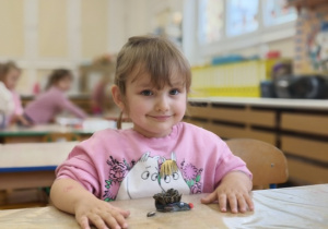 dziewczynka lepi jezyka z plasteliny i ziaren słonecznika