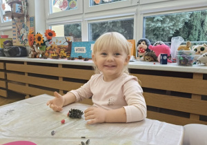 dziewczynka lepi jezyka z plasteliny i ziaren słonecznika