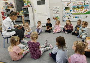 dzieci siedzą w kole i słuchają Pani pielęgniarki