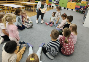 dzieci oglądają obrazki pokazywane przez Panią pielęgniarkę