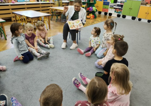 dzieci oglądają obrazki pokazywane przez Panią pielęgniarkę