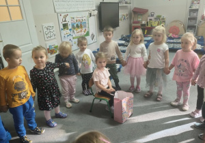 dzieci stoją w kole i śpiewają sto lat Róży