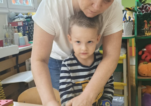 dzieci stemplują rączką na kartonie podpisując kodeks grupy