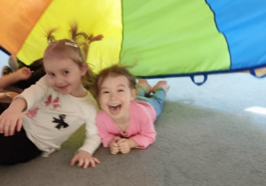 uśmiechnięte dziewczynki leżą pod chuta animacyjną