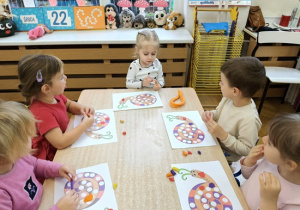 dzieci wyklejaja muszelkę ślimaka