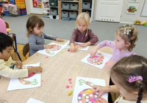 dzieci wyklejają muszelkę ślimaka