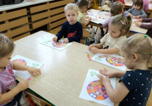 dzieci wyklejają muszelkę ślimaka