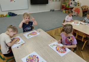 dzieci wyklejają muszelkę ślimaka