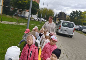 dzieci idą przy zabawkowym wężu na spacer