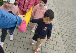 dzieci idą przy zabawkowym wężu na spacer
