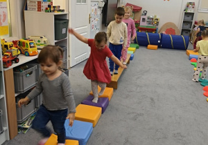dzieci idą po torze przeszkód z miękkich materacy